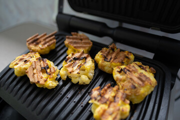 Cauliflower fried in an egg on an electric grill