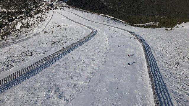 Aerial view of a ski resort in Navacerrada, Madrid, with people skiing in the slope