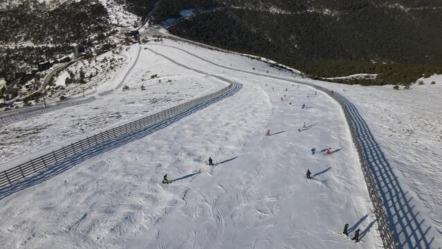 Aerial view of a group of people descending a hill practicing skiing, in the Navacerrada ski station, Madrid, Spain