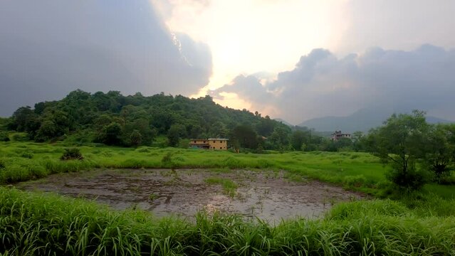A Beautiful View of a mountain near a small village and farm and a small lake | Beautiful green forest in Maharashtra, India Monsoon season background with stormy clouds landscape