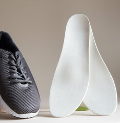 Gray sport shoes  with orthopedic insoles. Foot care products conception.