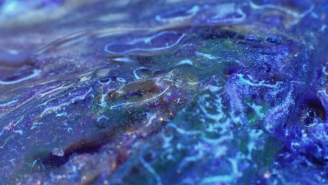 Water pollution. Microplastic contamination. Ecology problem. Glittering waste flowing on textured ice surface