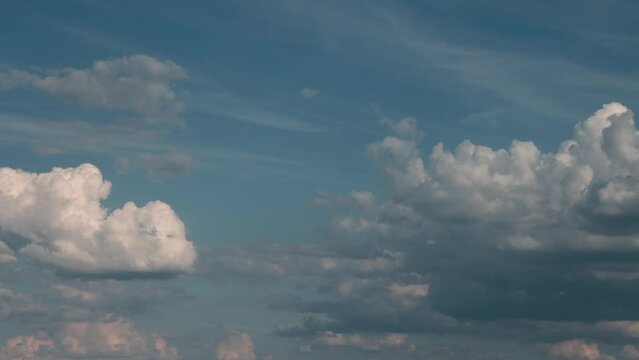 Timelapse of cumulus clouds moving in the blue sky. Light clouds change their shape in cloud space. 