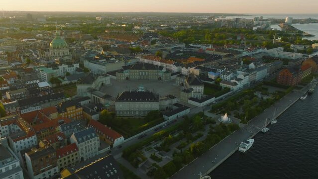 Amalienborg palace, royal residence and famous Frederiks Kirke against sunset. Aerial slide and pan footage of historic town buildings. Copenhagen, Denmark