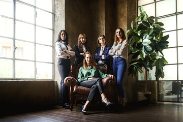 Corporate portrait of a group female businesswomen colleagues standing in the office arms crossed -...