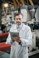 Engineer with tablet working at polymer factory