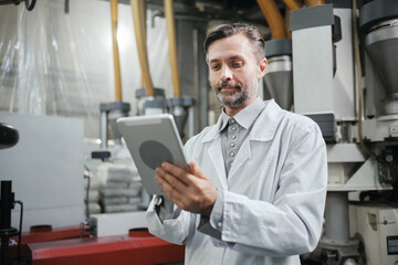 Engineer with tablet working at polymer factory