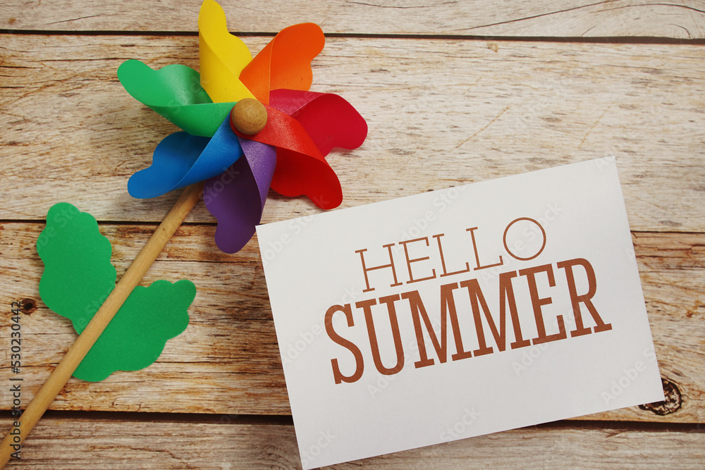 Poster hello summer text message with windmill on wooden background