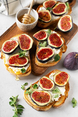 Fig bruschetta, bread and cream cheese and fruit on white background
