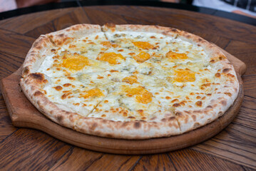 Cheese pizza on a wooden plate