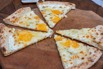 Cheese pizza on a wooden plate