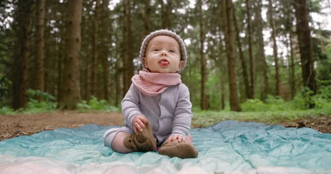 Baby Wearing Beanie Sitting On Blanket In The Forest