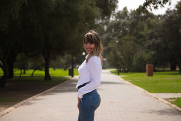 Fototapeta premium Pretty, blonde, young woman is posing as a model doing different poses and body expressions. The woman is on holiday in the city. Travel and holiday concept, beauty and fashion.