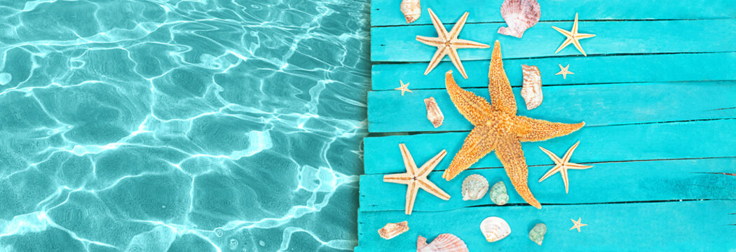 Wooden blue sea decking, boards with orange and white starfish, seashells near pool. Concept of vacation, tourism, summer. Copy space