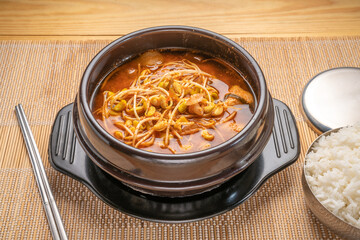 Korean traditional food, Soybean sprout soup in hot iron pot on wooden table, Kongnamul guk.