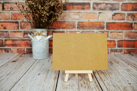 Mock up empty blank paper card on wooden easel with dried flowers bouquet