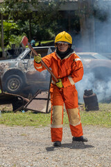 Naklejka premium Firefighters wearing helmets with fire safety equipment Use Twirl aerosol fire extinguishers to fight oil flames.Preventing fire accidents is an industrial safety concept. 