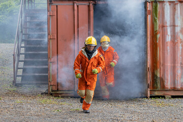 Firefighters wearing helmets with fire safety equipment Use Twirl aerosol fire extinguishers to...
