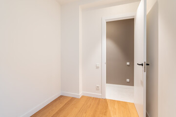 Empty room with laminate flooring and newly painted white walls. Repair and construction concept.