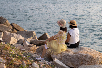 two stylish ladies girls pose group photos at rocky beach near West Kowloon Waterfront Promenade, Hong Kong