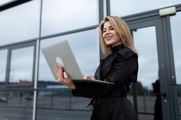 online work concept of a modern woman on the background of an office building