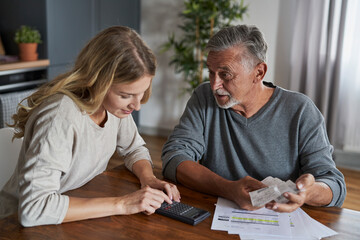 Senior man with adult daughter looking for solution in financial problem. Documents prepare special...