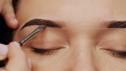 Woman is  on the Eyebrow coloring procedure. Professional lamination procedures of female eyebrows...