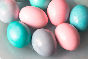 Light pink and turquoise, blue eggs on a blue plate and a gray background for the Easter holiday