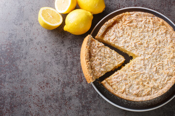 Homemade grated cake tart with lemon curd close-up in a plate on the table. Horizontal top view from above