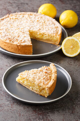 Tasty Sliced Lemon tart sprinkled with icing sugar close-up in a plate on the table. Vertical