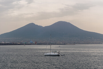 Sailboat on Gulf of Naples on the Mediterranean sea with Mount Vesuvius in the background