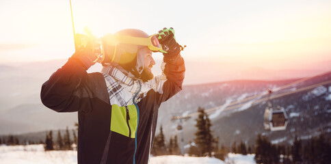 Naklejka premium Snowboarder man stands background ski resort sunset. Concept banner winter travel, Sheregesh Kemerovo region Russia