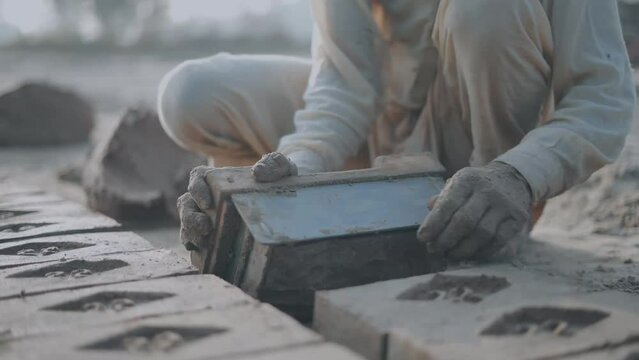 man making bricks out of mud