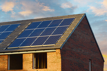 Naklejka premium Photovoltaic solar panels on the roof of new house. Roof with solar panels