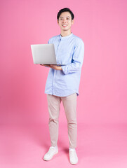 Young Asian man using laptop in background