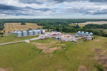 Fototapeta na wymiar aerial view on rows of agro silos granary elevator with seeds cleaning line on agro-processing manufacturing plant for processing drying cleaning and storage of agricultural products