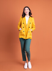 Full length photo of young Asian woman on background