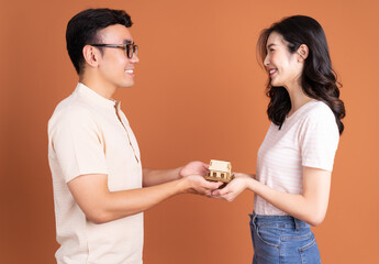 Young Asian couple holding concept house on background