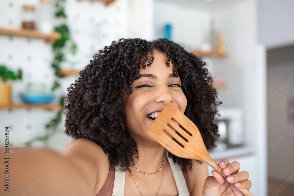 Wall mural young african american woman food blogger taking a selfie with a welder