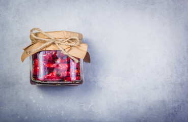 Fototapeta na wymiar Homemade sundried tomatoes on a gray background. Dried tomatoes in a jar copy space