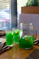 Tropical green lemonade with ice in a decanter. High quality photo