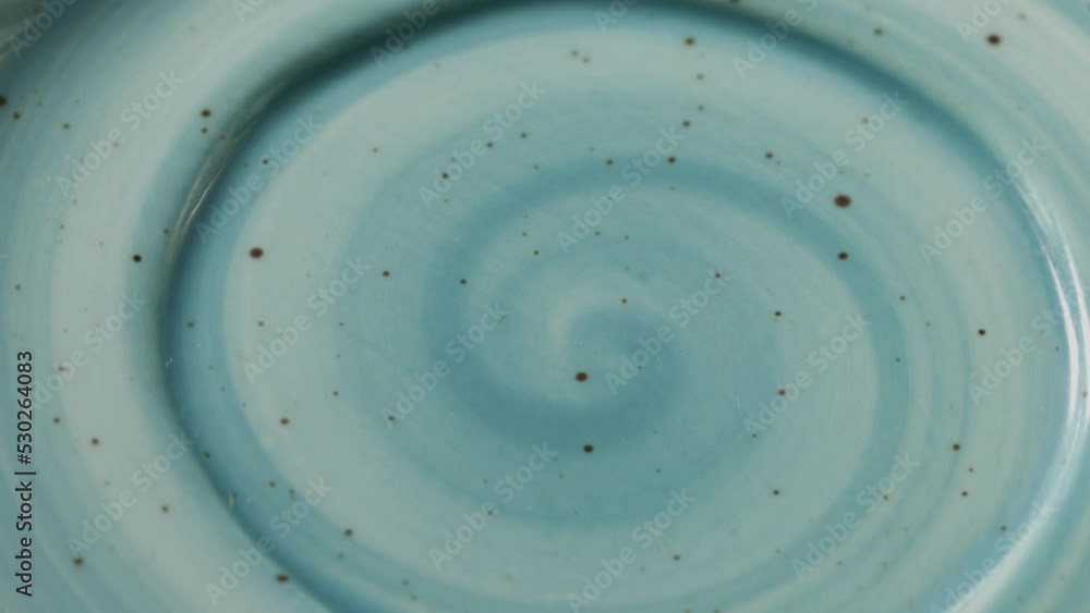 Poster a beautiful blue plate with a pattern in the shape of a spiral rotates in a circle
