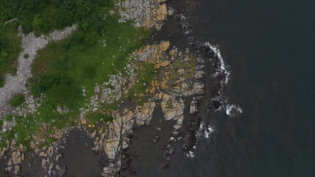 High birdsview footage over the waves hitting the shorelines at the danish summer island Bornholm.