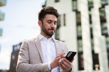 Obraz na płótnie Canvas Businessman using his cellphone on a city road