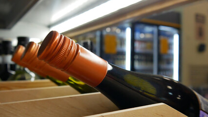 Close-up of a wooden rack with beautiful bottles of wine in alcoholic department