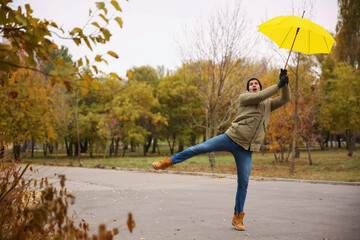 Man with yellow umbrella caught in gust of wind outdoors