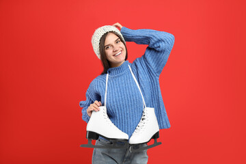 Happy woman with ice skates on red background