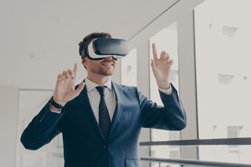 Excited office worker in vr headset or virtual reality goggles gesturing with hands