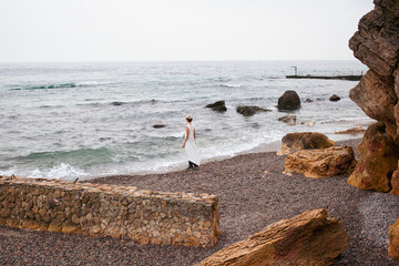 Fototapeta na wymiar hipster woman wearing dress near sea in autumn