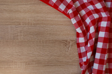 Checkered picnic cloth on wooden table, top view. Space for text